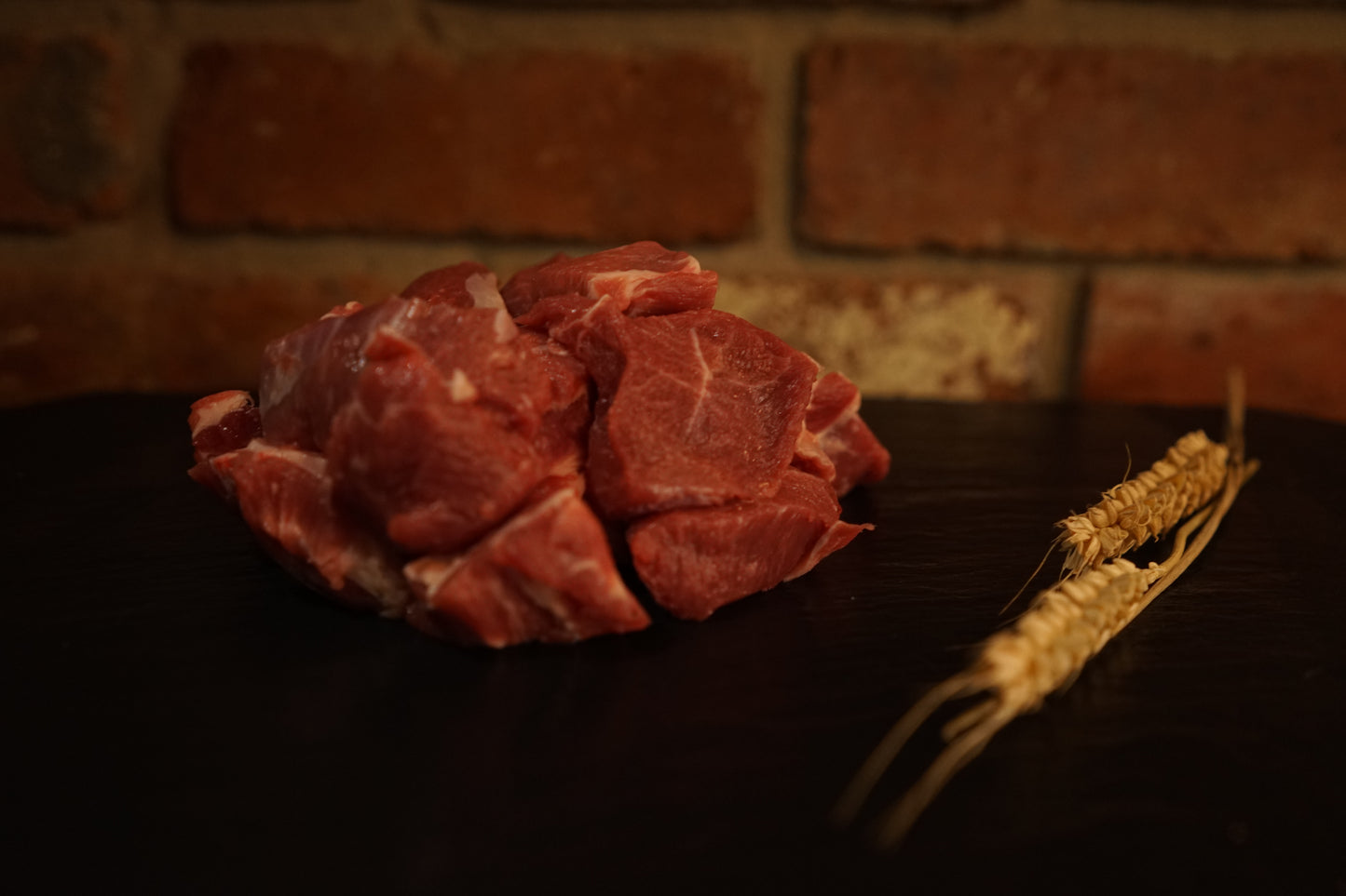 A small portion of diced Lamb Shoulder on a slate chopping board