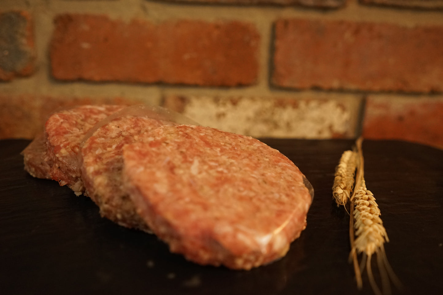 4 Pork & Apple Burgers on a slate chopping board