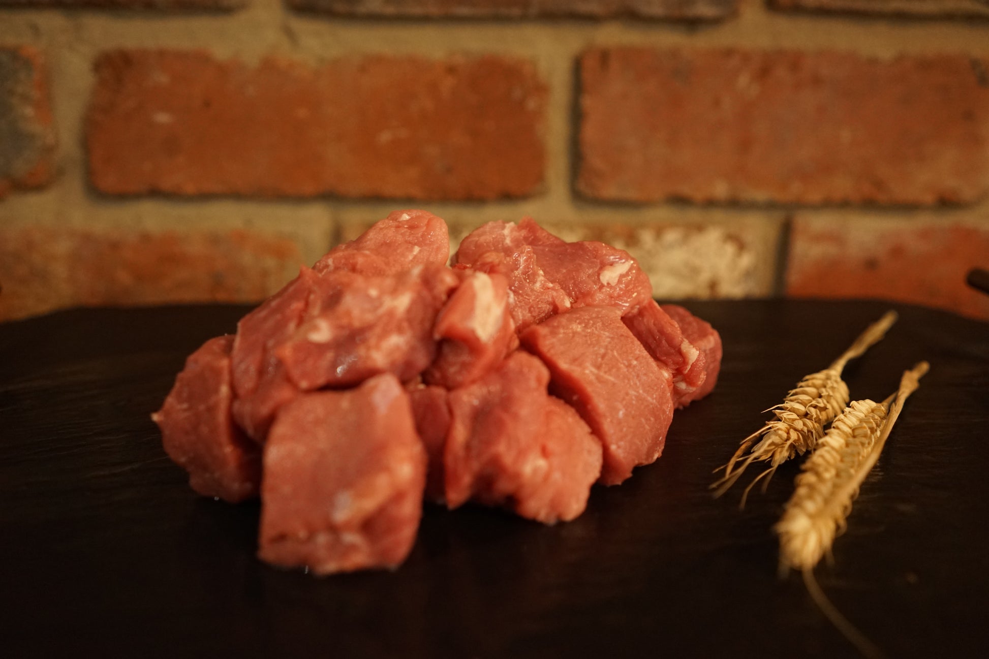 A small portion of Diced Pork Shoulder on a slate chopping board 