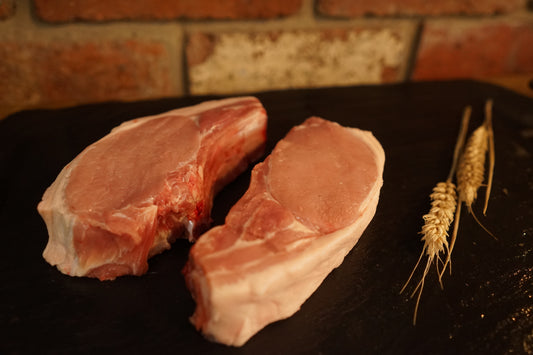 2 Pork Chops on a slate chopping board 