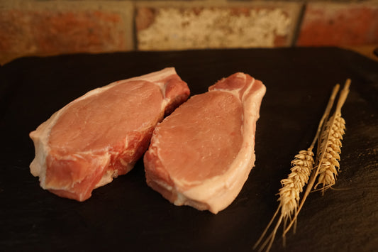 2 Pork Loin Steaks on a slate chopping board 